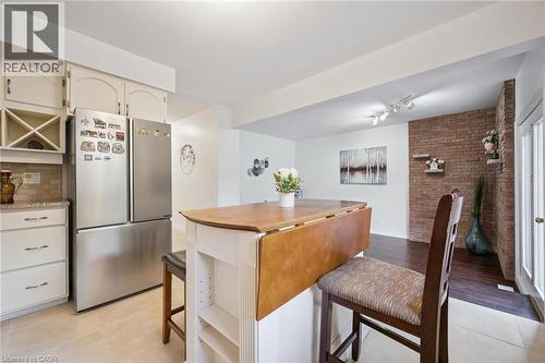 Kitchen with freestanding refrigerator, a kitchen breakfast bar, and light tile patterned floors - 599 Beechwood Drive, Waterloo, ON - Indoor