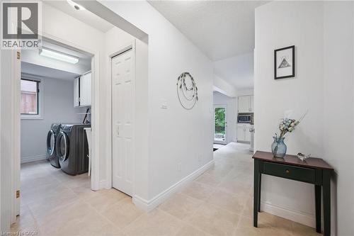 Hall featuring washing machine and dryer, light tile patterned floors, and a textured ceiling - 599 Beechwood Drive, Waterloo, ON - Indoor Photo Showing Laundry Room