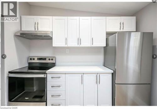 Kitchen with white cabinetry, stainless steel appliances, light countertops, and lofted ceiling - 1024 Cannon Street E, Hamilton, ON - Indoor Photo Showing Kitchen With Stainless Steel Kitchen