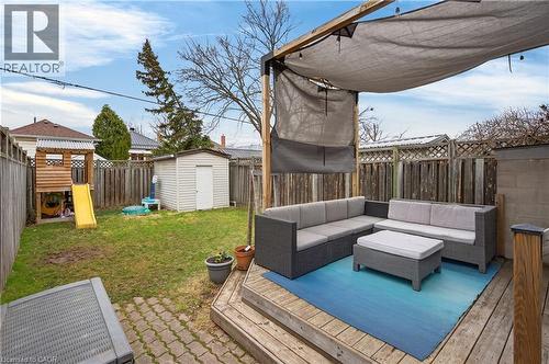 Wooden terrace with an outdoor hangout area, a fenced backyard, a shed, and a playground - 248 London Street S, Hamilton, ON - Outdoor With Deck Patio Veranda With Exterior