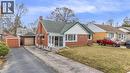 Bungalow-style home featuring a front lawn, brick siding, a garage, a chimney, and driveway - 41 Floral Crescent, Kitchener, ON  - Outdoor 
