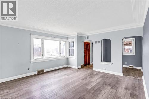 Unfurnished living room with ornamental molding, wood finished floors, a textured ceiling, and arched walkways - 41 Floral Crescent, Kitchener, ON - Indoor Photo Showing Other Room