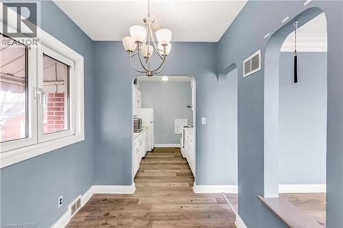 Corridor with arched walkways, light wood-style flooring, and a chandelier - 41 Floral Crescent, Kitchener, ON - Indoor Photo Showing Other Room