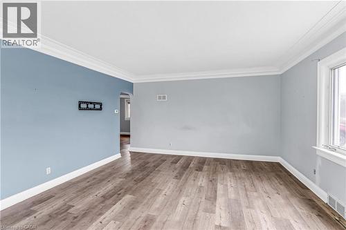 Empty room with arched walkways, light wood-style floors, and ornamental molding - 41 Floral Crescent, Kitchener, ON - Indoor Photo Showing Other Room