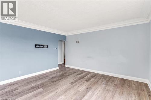 Empty room featuring arched walkways, light wood finished floors, and ornamental molding - 41 Floral Crescent, Kitchener, ON - Indoor Photo Showing Other Room