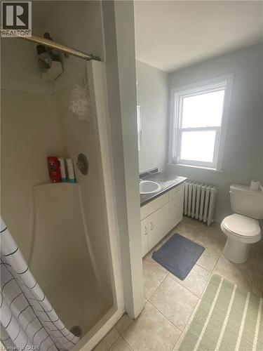 Bathroom with radiator heating unit, a shower stall, vanity, and light tile patterned flooring - 9 Waterloo Avenue, Guelph, ON - Indoor Photo Showing Bathroom