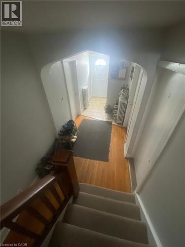 Staircase featuring wood finished floors and radiator heating unit - 9 Waterloo Avenue, Guelph, ON - Indoor Photo Showing Other Room