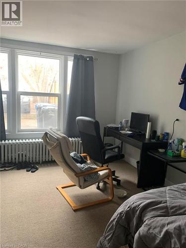 Carpeted bedroom with an office area and radiator heating unit - 9 Waterloo Avenue, Guelph, ON - Indoor