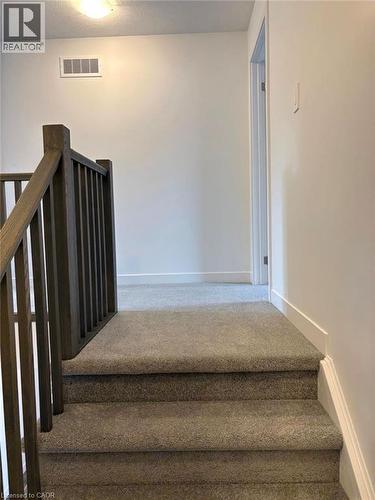 Staircase with carpet and a textured ceiling - 7 Pin Oak Common, Cambridge, ON - Indoor Photo Showing Other Room