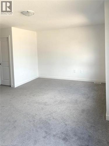 Carpeted empty room featuring baseboards - 7 Pin Oak Common, Cambridge, ON - Indoor Photo Showing Other Room