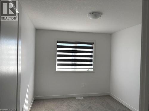 Empty room featuring light colored carpet and baseboards - 7 Pin Oak Common, Cambridge, ON - Indoor Photo Showing Other Room
