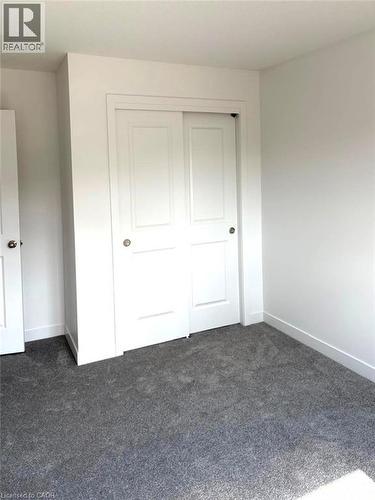 Unfurnished bedroom with dark carpet and a closet - 7 Pin Oak Common, Cambridge, ON - Indoor Photo Showing Other Room