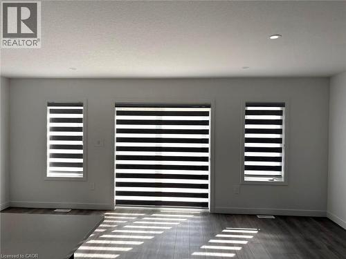 Detailed view of wood finished floors and recessed lighting - 7 Pin Oak Common, Cambridge, ON - Indoor Photo Showing Other Room
