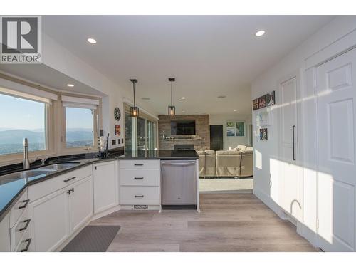 Pantry and door to downstairs on the right - 702 Cypress Drive, Coldstream, BC - Indoor Photo Showing Kitchen With Double Sink