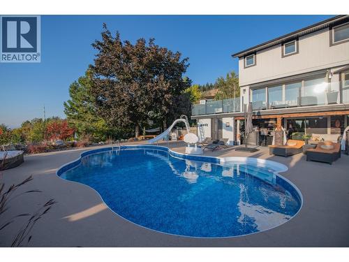 Concrete patio all around - 702 Cypress Drive, Coldstream, BC - Outdoor With In Ground Pool With Deck Patio Veranda With Backyard