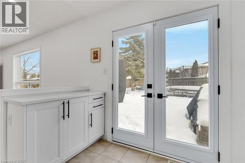The property features white cabinetry with black hardware, a light-colored countertop, and a tiled floor - 191 Hawkswood Trail, Hamilton, ON - Indoor Photo Showing Other Room