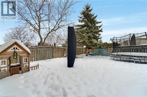 The property features a fenced backyard with a wooden playhouse and mature trees - 191 Hawkswood Trail, Hamilton, ON - Outdoor