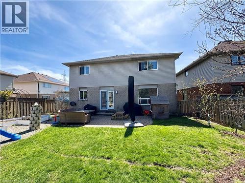 Expansive backyard featuring a manicured lawn, a paver patio, brick and siding exterior, and a privacy fence - 191 Hawkswood Trail, Hamilton, ON - Outdoor With Deck Patio Veranda