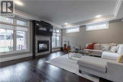 Living room with crown molding, a glass covered fireplace, plenty of natural light, dark wood finished floors, and recessed lighting - 2719 Torrey Pines Way, London, ON - Indoor With Fireplace