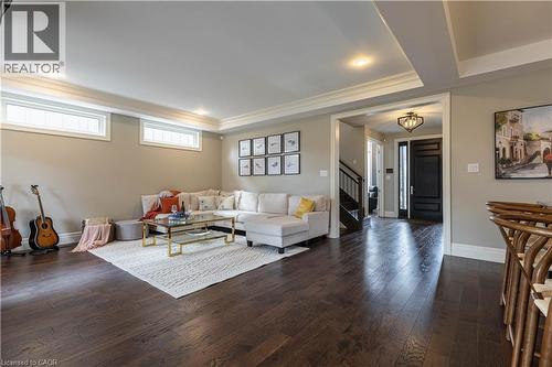 Living area featuring dark wood-style floors, ornamental molding, and a tray ceiling - 2719 Torrey Pines Way, London, ON - Indoor