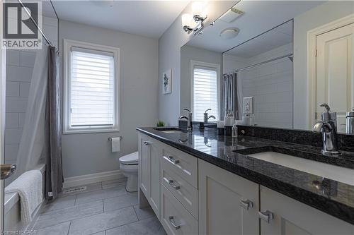 Full bathroom with double vanity, healthy amount of natural light, shower / tub combo with curtain, and light tile patterned floors - 2719 Torrey Pines Way, London, ON - Indoor Photo Showing Bathroom