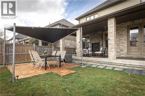 Fenced yard featuring an outdoor stone fireplace, a patio area, and outdoor dining area - 2719 Torrey Pines Way, London, ON - Outdoor With Deck Patio Veranda