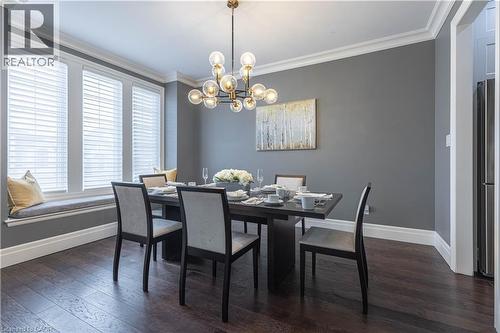 Dining room featuring suspended lighting, dark wood-type flooring, and ornamental molding - 2719 Torrey Pines Way, London, ON - Indoor Photo Showing Dining Room