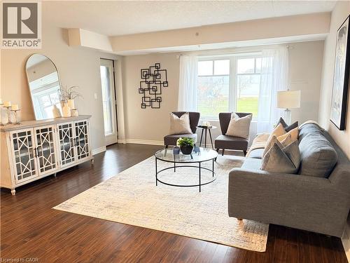 Living area with dark wood finished floors, plenty of natural light, and a textured ceiling - 776 Laurelwood Drive Unit# 406, Waterloo, ON - Indoor Photo Showing Living Room