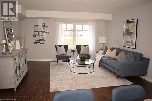 Living area featuring dark wood-type flooring and a textured ceiling - 776 Laurelwood Drive Unit# 406, Waterloo, ON - Indoor Photo Showing Living Room