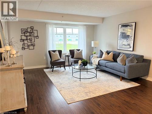 Living room with dark wood-type flooring and a textured ceiling - 776 Laurelwood Drive Unit# 406, Waterloo, ON - Indoor Photo Showing Living Room