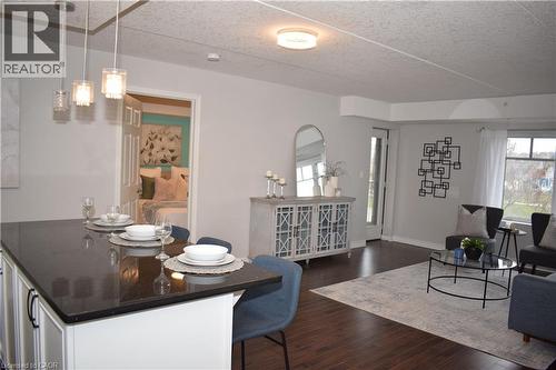 Dining area with dark wood-type flooring and a textured ceiling - 776 Laurelwood Drive Unit# 406, Waterloo, ON - Indoor