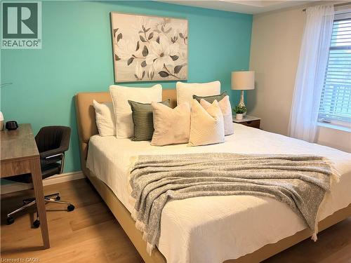 Bedroom featuring wood finished floors and an office area - 776 Laurelwood Drive Unit# 406, Waterloo, ON - Indoor Photo Showing Bedroom