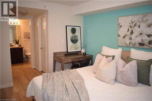 Bedroom with wood finished floors and ensuite bath - 776 Laurelwood Drive Unit# 406, Waterloo, ON - Indoor Photo Showing Bedroom