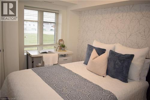 Bedroom featuring wallpapered walls and an accent wall - 776 Laurelwood Drive Unit# 406, Waterloo, ON - Indoor Photo Showing Bedroom