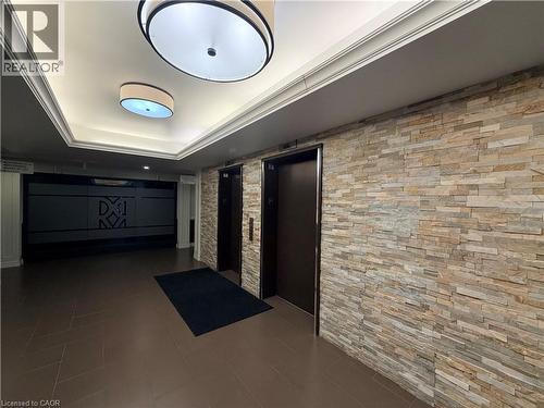 Hallway featuring elevator, dark tile patterned flooring, and a raised ceiling - 776 Laurelwood Drive Unit# 406, Waterloo, ON - Indoor Photo Showing Other Room
