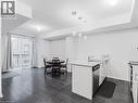 Kitchen featuring white cabinetry, a peninsula, dark wood finished floors, hanging light fixtures, and light stone countertops - 1206 Main Street E Unit# 113, Milton, ON  - Indoor Photo Showing Other Room 