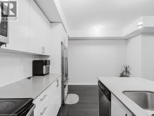 Kitchen featuring white cabinets, black range with electric cooktop, dishwasher, dark wood finished floors, and high end fridge - 1206 Main Street E Unit# 113, Milton, ON - Indoor Photo Showing Kitchen