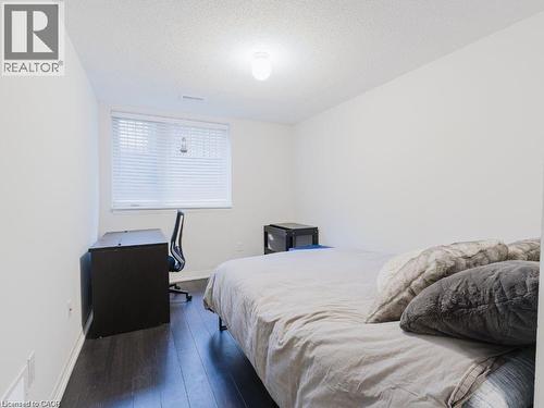 Bedroom with a textured ceiling, dark wood finished floors, and a desk - 1206 Main Street E Unit# 113, Milton, ON - Indoor Photo Showing Bedroom
