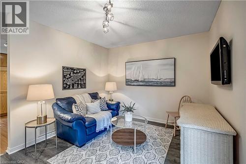 Living area featuring a textured ceiling, wood finished floors, and track lighting - 640 Acadia Drive, Hamilton, ON - Indoor Photo Showing Living Room