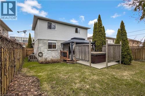 Rear view of house with brick siding, a gazebo, a deck, a fenced backyard, and a hot tub - 640 Acadia Drive, Hamilton, ON - Outdoor