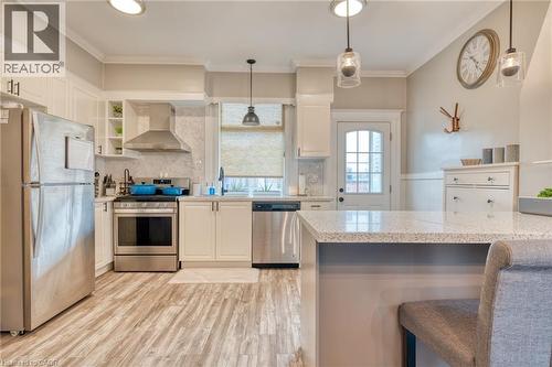 Kitchen featuring stainless steel appliances, a breakfast bar, white cabinets, light wood finished floors, and open shelves - 37 Cliff Avenue, Hamilton, ON - Indoor Photo Showing Kitchen With Upgraded Kitchen