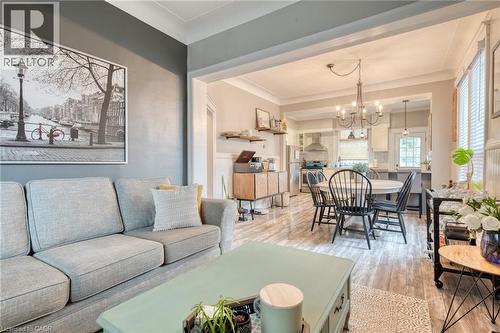 Living room featuring light wood-type flooring, suspended lighting, and crown molding - 37 Cliff Avenue, Hamilton, ON - Indoor Photo Showing Living Room
