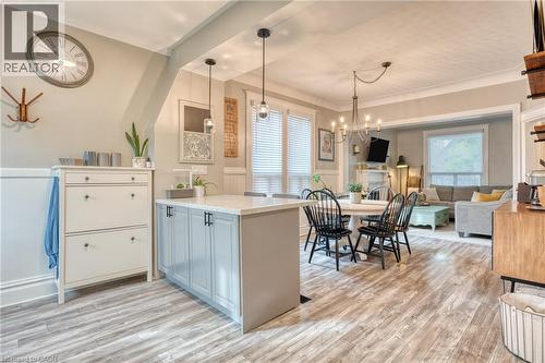 Kitchen featuring a wainscoted wall, a peninsula, light wood-style flooring, ornamental molding, and open floor plan - 37 Cliff Avenue, Hamilton, ON - Indoor Photo Showing Dining Room
