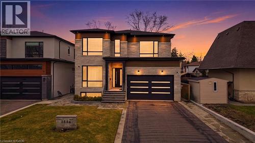 View of front of home with stone siding, driveway, a garage, and a yard - 2556 Glengarry Road, Mississauga, ON - Outdoor