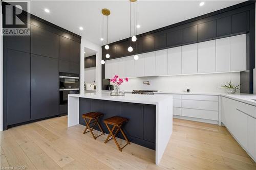 Two tone kitchen with modern cabinets, light wood finished floors, hanging light fixtures, and two tone color scheme - 2556 Glengarry Road, Mississauga, ON - Indoor Photo Showing Kitchen With Upgraded Kitchen