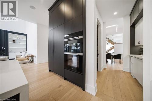 Kitchen with light wood finished floors, dark cabinets, modern cabinets, and recessed lighting - 2556 Glengarry Road, Mississauga, ON - Indoor