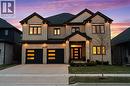 View of front of home featuring concrete driveway, a yard, brick siding, a garage, and board and batten siding - 39 Mill Race Crescent, St. Jacobs, ON  - Outdoor With Facade 