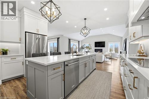 Kitchen with hanging lights, stainless steel appliances, two tone cabinets, lofted ceiling, and an island with sink - 39 Mill Race Crescent, St. Jacobs, ON - Indoor Photo Showing Kitchen With Upgraded Kitchen