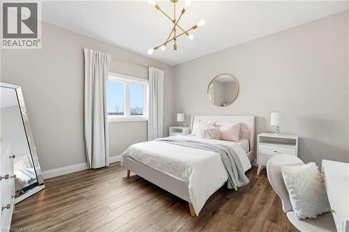 Bedroom featuring wood finished floors and a chandelier - 39 Mill Race Crescent, St. Jacobs, ON - Indoor Photo Showing Bedroom