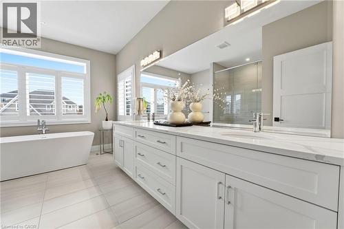 Full bathroom featuring a stall shower, double vanity, light tile patterned flooring, and a soaking tub - 39 Mill Race Crescent, St. Jacobs, ON - Indoor Photo Showing Bathroom